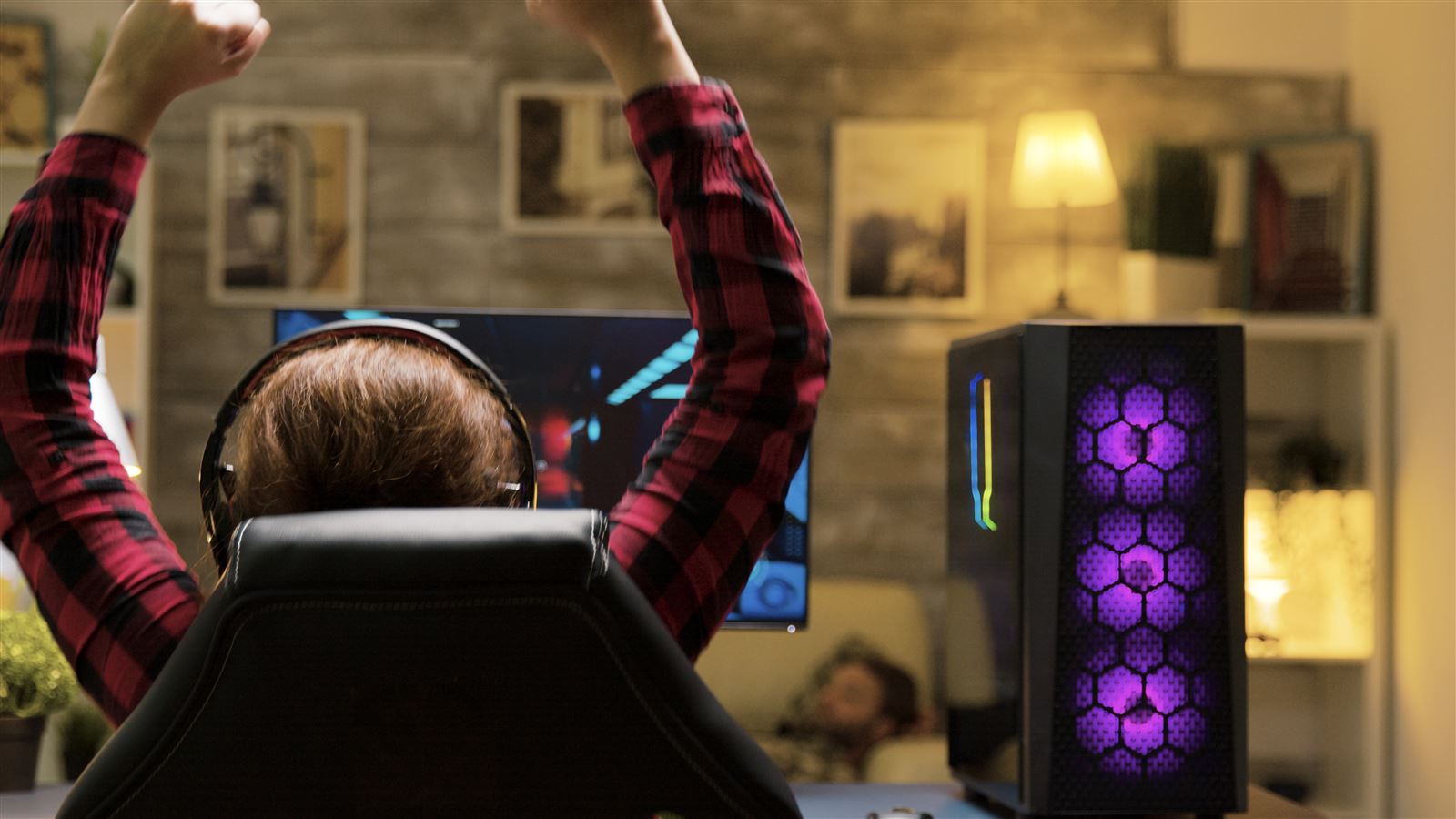 Gamer celebrating a win at a custom RGB gaming PC