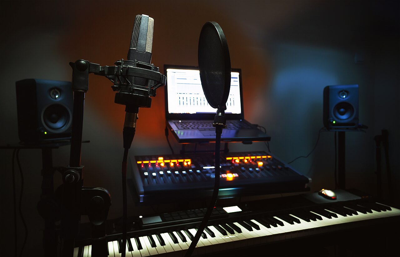 Home recording studio with microphone, laptop running a DAW, controller and MIDI keyboard
